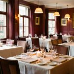 Salle de restaurant élégante et chaleureuse, soigneusement dressée pour accueillir des clients en semaine