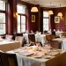 Salle de restaurant élégante et chaleureuse, soigneusement dressée pour accueillir des clients en semaine